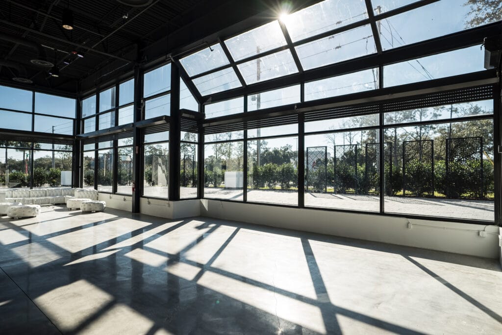 wall of windows with sun shining through and view of trees outside